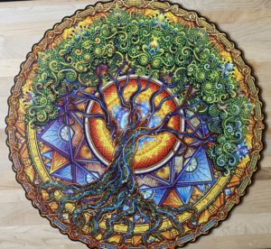 A circular puzzle of a colorful tree mandala on a wooden background.